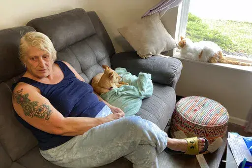 Janna Sharrett relaxes at home on a day off from her job as a full-time customer service rep for a contact lens and eyeglass company, on Tuesday, Nov. 1, 2022, in Grove City, Ohio. Sharrett earns $14.94 an hour but pays just $695 a month in rent thanks to the affordable housing apartment developed by a local nonprofit to expand the number of low-rent options in central Ohio. A shortage of housing of all kinds in the region is raising concerns as Intel Corp. develops a $20 billion project expecte