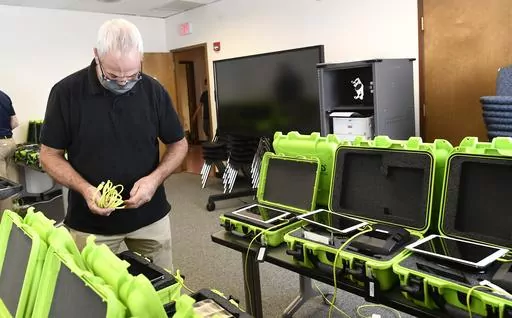 Mark Splonskowski assembles electronic poll book kits that voters will use to sign in at polling locations at the Albany County Board of Elections building, Oct. 14, 2020, in Albany, N.Y. An effort to create a national testing program for technology central to U.S elections will get underway later this year. The aim is to strengthen the security of equipment that's been targeted by foreign governments and that's provided fertile ground for conspiracy theories. (AP Photo/Hans Pennink, File)