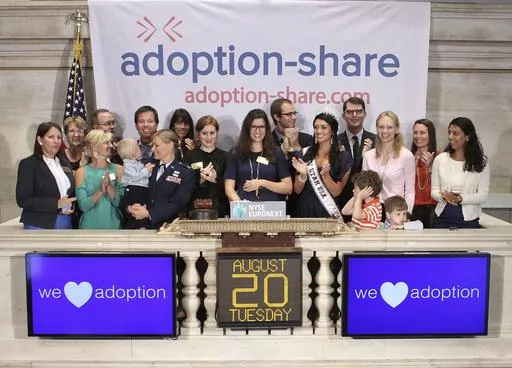 In this photo provided by the New York Stock Exchange, Adoption-Share founder and CEO Thea Ramirez, center, Miss Utah USA 2013 Marissa Powell, center right, and fellow adoption supporters ring the opening bell at the New York Stock Exchange in New York on Aug. 20, 2013. An Associated Press investigation found that Adoption-Share’s tool known as Family-Match – among the few adoption algorithms on the market in 2023 – has produced limited results in the states where it has been used, accordi