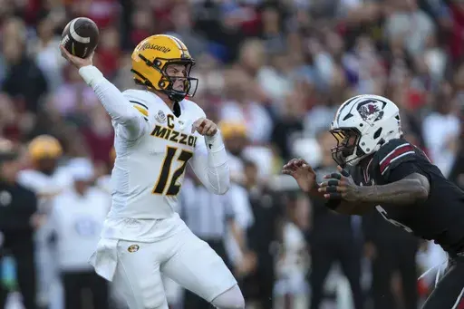 Missouri quarterback Brady Cook (12) is hurried by South Carolina edge rusher Dylan Stewart (6) during the first half of an NCAA college football game Saturday, Nov. 16, 2024, in Columbia, S.C. (AP Photo/Artie Walker Jr.)