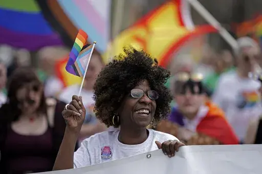 Teresa Parks walks in the Little Apple Pride parade Saturday, April 23, 2022, in Manhattan, Kan. Inspired by protests following the death of George Floyd, parks co-founded a Black Lives Matter group and as part of a task force has pushed for more inclusion for people from diverse backgrounds in the predominantly white community. (AP Photo/Charlie Riedel)