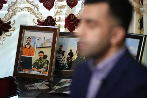 Photographs of Abdul Wasi Safi sit on a table as his brother, Sami-ullah Safi talks about his brother's journey to the U.S. during an interview Wednesday, Jan. 18, 2023, in Houston. Abdul Wasi Safi was an intelligence officer with the Afghan National Security Forces, providing U.S. armed forces with information for operations against terrorists, said Sami-ulllah Safi. Wasi, as he is called by his family, was arrested after crossing the U.S.-Mexico border near Eagle Pass, Texas in September 2022,