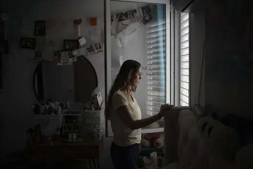 Lilach Almog talks about the Hamas attack on the police department in her city on Oct. 7, 2023, during an interview at her apartment in Sderot, Israel, Sunday, Sept. 22, 2024. Almog, who lives across from the police station that was destroyed during the attack, witnessed the movements of the Hamas militants and Israeli forces from her bedroom window. (AP Photo/Leo Correa)