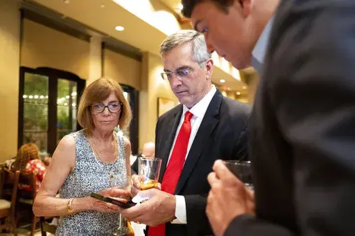 Incumbent Georgia Secretary of State Brad Raffensperger, checks returns with supporters during an election night party Tuesday evening, May 24, 2022, at a small restaurant in Peachtree Corners, Ga. (AP Photo/Ben Gray)