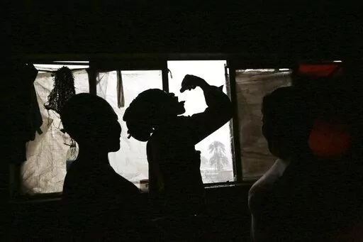 A man takes cough medicine used as a drug in Mbare, Harare, in this Saturday, Nov. 20, 2021. In Zimbabwe, the COVID-19 pandemic has driven up mental health problems caused by substance abuse. Health professionals are seeing a marked rise in crises caused by drug use. Authorities and campaigners attribute the rise in drug abuse to loss of employment, prolonged school closures, stress and anxiety resulting from COVID-19. ( AP Photo/Tsvangirayi Mukwazhi)