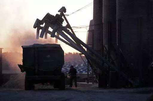 A feed truck is loaded at dawn at the Flood Brothers Farm, Monday, April 1, 2024, in Clinton, Maine. Foreign-born workers make up fully half the farm's staff of nearly 50, feeding the cows, tending crops and helping collect the milk — 18,000 gallons every day. (AP Photo/Robert F. Bukaty)