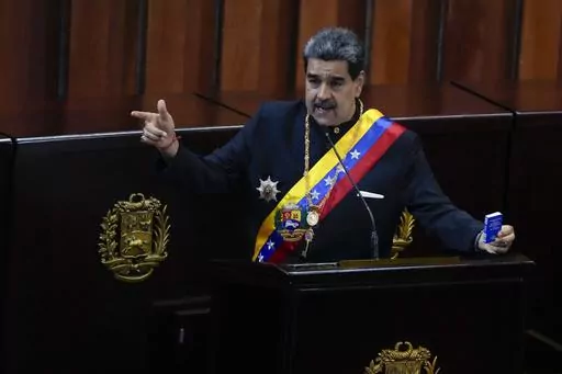 Venezuelan President Nicolas Maduro holds a small copy of his nation's constitution during ceremony marking the start of the judicial year at the Supreme Court in Caracas, Venezuela, Jan. 31, 2024. A secret memo obtained by The Associated Press details a covert operation by the U.S. Drug Enforcement Administration that sent undercover operatives into Venezuela to record and build drug-trafficking cases against the country’s leadership including Venezuelan President Nicolás Maduro. (AP Photo/A