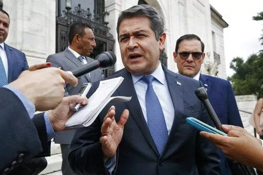 Honduran President Juan Orlando Hernandez answers questions from the Associated Press, Tuesday, Aug. 13, 2019, as he leaves a meeting at the Organization of American States, in Washington. The U.S. government is formally requesting on Monday, Feb. 14, 2022, the arrest and extradition of ex-president Hernandez. (AP Photo/Jacquelyn Martin,File)