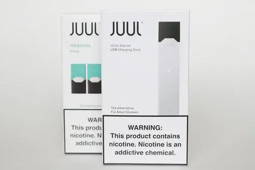 Packaging for an electronic cigarette and menthol pods from Juul Labs is displayed on Feb. 25, 2020, in Pembroke Pines, Fla. In a deal announced Tuesday, Sept. 6, 2022, electronic cigarette maker Juul Labs will pay nearly $440 million to settle a two-year investigation by 33 states into the marketing of its high-nicotine vaping products, which have long been blamed for sparking a national surge in teen vaping. (AP Photo/Brynn Anderson, File)