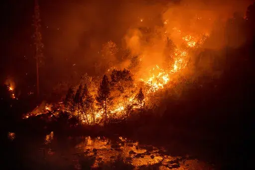The Caldor Fire burns above the South Fork of the American River in the White Hall community of El Dorado County, Calif., on Friday, Aug. 27, 2021. (AP Photo/Noah Berger)