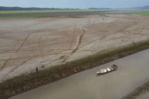 Fishermen push a boat in the Aleixo Lake amid a drought in Manaus, Amazonas state, Brazil, Sept. 24, 2024. (AP Photo/Edmar Barros, File)