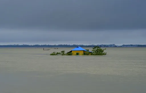 A house stands surrounded by floodwaters in Sylhet, Bangladesh, Monday, June 20, 2022. Early and strong monsoon rains have brought heavy flooding to northeastern India and Bangladesh, killing dozens of people, forcing hundreds of thousands from their homes and cutting millions off from crucial supplies. (AP Photo/Mahmud Hossain Opu)