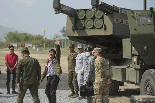 Philippine President Ferdinand Marcos Jr. waves beside a U.S. M142 High Mobility Artillery Rocket System (HIMARS) during a Combined Joint Littoral Live Fire Exercise at the joint military exercise called "Balikatan," Tagalog for shoulder-to-shoulder in a Naval station in Zambales province, northern Philippines on Wednesday, April 26, 2023. The long-time treaty allies are holding their largest joint military exercises that are part of a show of American firepower that has alarmed China. (AP Photo