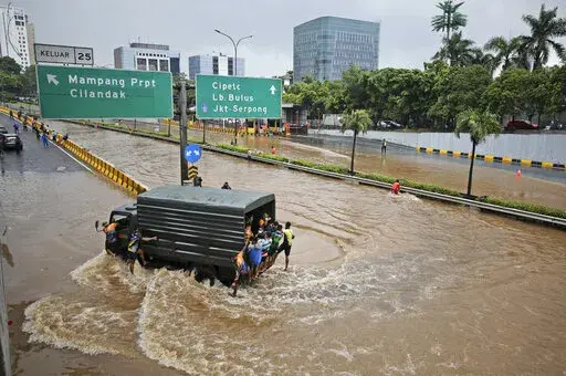 A military truck drives through the water on a flooded toll road following heavy rains in Jakarta, Indonesia, Saturday, Feb. 20, 2021. A United Nations Intergovernmental Panel on Climate Change report released on Monday, Feb. 28, 2022, says a staggering 143 million people will be uprooted over the next 30 years by rising seas, searing temperatures and other climate calamities. (AP Photo/Dita Alangkara, File)
