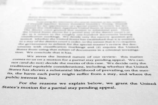 A page from a U.S. Court of Appeals for the 11th Circuit in Atlanta ruling that lifts a judge's hold on the Justice Department's ability to use classified documents seized by the FBI at Trump's Mar-a-Lago estate, is photographed Wednesday, Sept. 21, 2022. The ruling clears the way for the department to immediately resume its use of the documents in its investigation.(AP Photo/Jon Elswick)