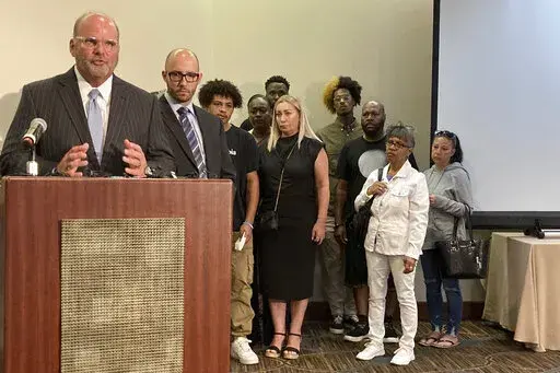 Attorney Rex Elliott addresses reporters with the extended family of Donovan Lewis behind him, on Thursday, Sept. 1, 2022, in Columbus. Ohio. Elliott said the early Tuesday morning shooting death of Lewis at the hands of police was senseless and reckless and he called for immediate new police reforms. (AP Photo/Andrew Welsh-Huggins)