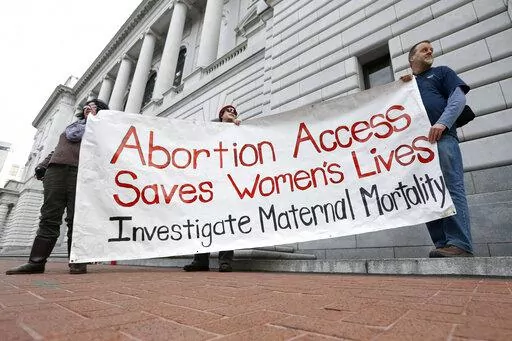 Bill Lambert, right, Phil Walk, center, and Brenda Serrato demonstrate outside of the 5th U.S. Circuit Court of Appeals on Jan. 7, 2015, in New Orleans. States with some of the nation's strictest abortion laws are also some of the hardest places to have and raise a healthy child, especially for the poor, according to an analysis of federal data by The Associated Press. (AP Photo/Jonathan Bachman, File)